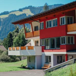 a red building with a balcony on a hill at Siegi's Apartments in Hof