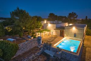 une villa avec une piscine la nuit dans l'établissement Masseria Luci, à Maglie