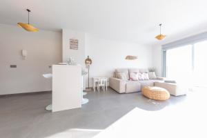 a white living room with a couch and a table at MEDANO4YOU The Casa Celou Penthouse in La Tejita