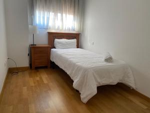 Apartment Madrid Barajas في مدريد: غرفة نوم بسرير وخزانة ونافذة