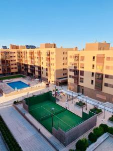 un complejo de apartamentos con pista de tenis y edificios en Apartment Madrid Barajas en Madrid