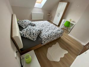 um pequeno quarto com uma cama e uma cadeira verde em B&B Home em Sighisoara