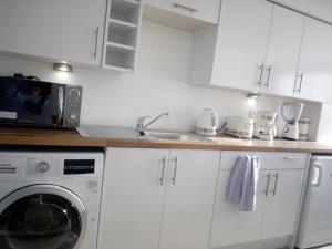 a kitchen with a washing machine and a sink at The Staithe by the Canal. in Lancaster +2 photos