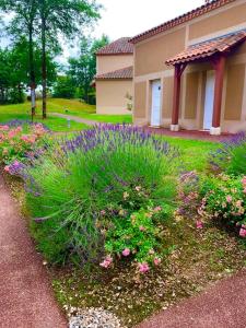 un giardino di fiori di fronte a una casa di Appartement dans joli village de vacances 47150 a Monflanquin