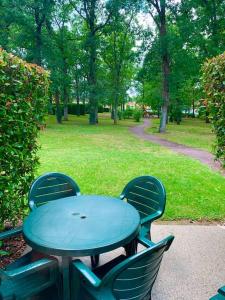 a blue table and chairs in a park at Appartement dans joli village de vacances 47150 in Monflanquin