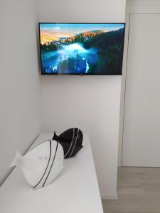 a television on a white wall in a living room at Jesolo Appartamenti F2 - Black and White in Lido di Jesolo