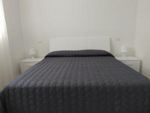 a bed in a bedroom with two night stands at Jesolo Appartamenti F2 - Black and White in Lido di Jesolo