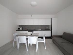 kuchnia ze stołem, krzesłami i kanapą w obiekcie Jesolo Appartamenti F2 - Black and White w mieście Lido di Jesolo