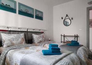 two beds in a bedroom with blue towels on them at YARD 151 in Noventa di Piave