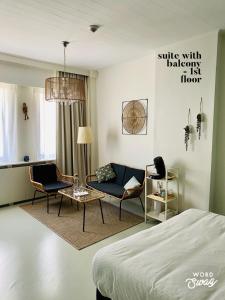 1 dormitorio con 1 cama, 1 silla y 1 sofá en Studio Heyst en Knokke-Heist