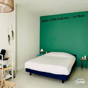 a bedroom with a bed with a green wall at Studio Heyst in Knokke-Heist