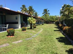 a yard of a house with plants and flowers at Privê Portal do Sol in Porto De Galinhas