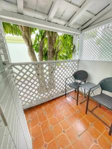 un balcón con 2 sillas y un árbol en The Casablanca Hotel, en Key West