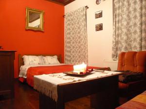 Zimmer mit 2 Betten und einer Kerze auf dem Tisch in der Unterkunft Philippos Hotel in Psarádes