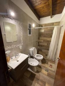 a bathroom with a white toilet and a sink at Hermosa casa en Tafí del Valle! in Tafí del Valle