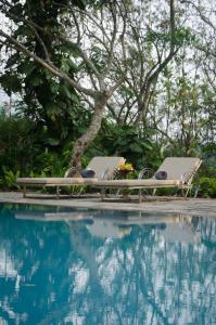 una mesa y sillas junto a una piscina en Stone House, Kandy, en Kandy