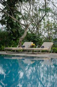 a table and chairs next to a swimming pool at Stone House, Kandy in Kandy