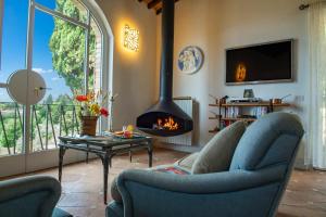 sala de estar con 2 sillas y chimenea en IL Castellano con jacuzzi e bellavista, en Castelfalfi