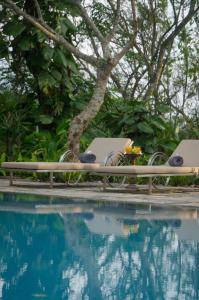 a table and chairs next to a swimming pool at Stone House, Kandy in Kandy