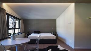 a bedroom with a bed and a table and a window at La Meira Sermig Casa Ferie in Crissolo