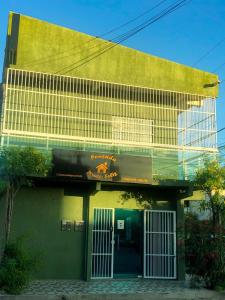Pousada Pouso Feliz في فورتاليزا: مبنى أخضر أمامه باب أبيض