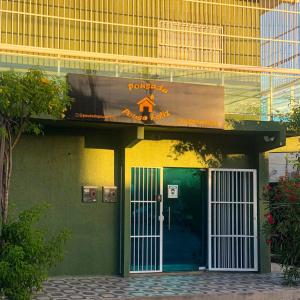 a green building with a door and a sign on it at Pousada Pouso Feliz in Fortaleza
