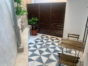 eine Terrasse mit einem Tisch, 2 Bänken und einem Boden in der Unterkunft Puerta de Caceres Apartamento 1 in Cáceres