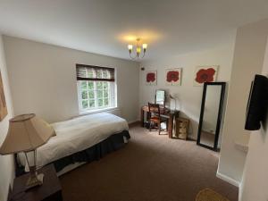 een slaapkamer met een bed en een raam bij Garden House in Nailsworth