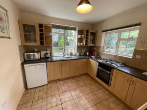 a kitchen with wooden cabinets and a white refrigerator at Garden House in Nailsworth +8 photos