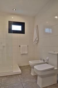 Un baño blanco con inodoro y ducha. en Espino Blanco Apartamentos, en San Carlos de Bariloche 37 fotos más