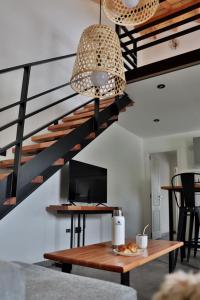 Una sala de estar con una mesa y una escalera. en Espino Blanco Apartamentos, en San Carlos de Bariloche