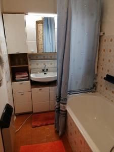 a bathroom with a sink and a tub and a mirror at Appartmenthaus Kern in Aigen im Mühlkreis