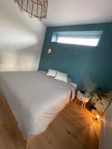 a bedroom with a large bed and a window at Le Revella in Profondeville