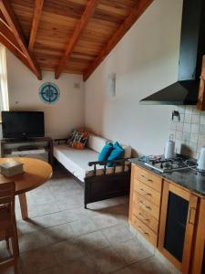 cocina y sala de estar con sofá y mesa en Departamento con piscina en San Martín de los Andes