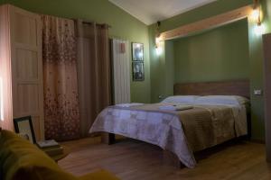 カステルメッツァーノにあるB&B Sud e Magiaの緑の壁のベッドルーム1室(ベッド2台付)