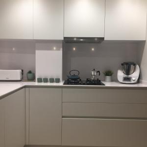 a kitchen with white cabinets and a stove top oven at BRAND NEW & BEST LOCATION!!! SPOTLESS APARTMENT in Sant Feliu de Guixols