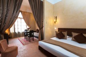 a bedroom with a bed and a chair and a table at Hapimag Resort Marrakesh in Douar Soukkane +71 photos