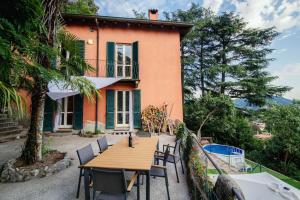 un tavolo e sedie di fronte a una casa di Villa Bertacchi - inside and out Como a Como