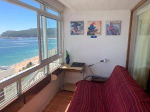 セジンブラにあるSesimbra Vista Mar & Vilaのベッドルーム1室(デスク付)が備わります。ビーチの景色を望めます。
