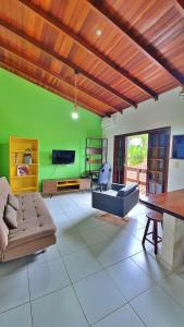 - un salon avec un canapé et un mur vert dans l'établissement Kitnet Superior com Vista para o Mar, à São Sebastião