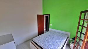 ein Schlafzimmer mit grünen und weißen Wänden und einem Bett in der Unterkunft Kitnet Superior com Vista para o Mar in São Sebastião