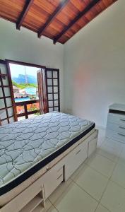 un grande letto in una stanza con una grande finestra di Kitnet Superior com Vista para o Mar a São Sebastião