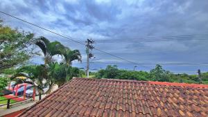 a tile roof of a house with palm trees at Kitnet Superior com Vista para o Mar in São Sebastião