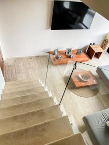 a room with a staircase with a tv and a table at Kataleya Tulum by Zaazil - New Luxury Penthouse Up to 10 people, 3-level, 3240 sqft , Private Pool, Terrace and Roof Top in Luum Zama in the Jungle in Tulum