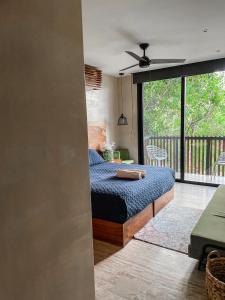 a bedroom with a bed and a balcony at Kataleya Tulum by Zaazil - New Luxury Penthouse Up to 10 people, 3-level, 3240 sqft , Private Pool, Terrace and Roof Top in Luum Zama in the Jungle in Tulum