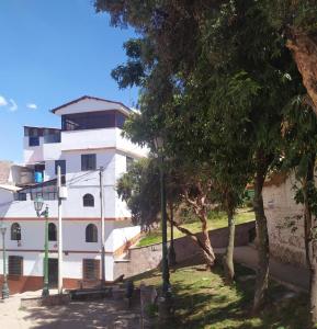 un edificio blanco con árboles delante de él en Casa Panorama B&B, en Cusco