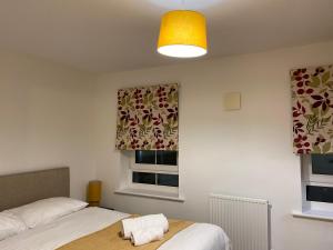 1 dormitorio con 2 camas y ventana en Spacious 2 Bed House for Corporate and Family Stays, en Basingstoke