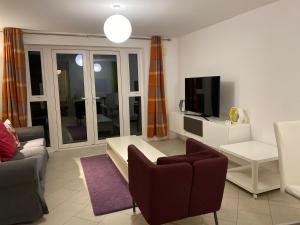 ein Wohnzimmer mit einem Sofa und einem TV in der Unterkunft Spacious 2 Bed House for Corporate and Family Stays in Basingstoke