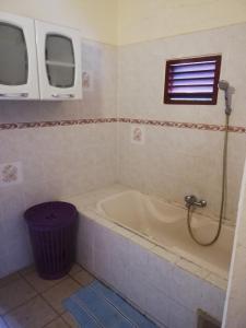 een badkamer met een bad en een raam bij Appartement avec vue sur mer in Bouillante