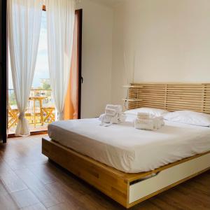 sypialnia z dużym łóżkiem z dwoma ręcznikami w obiekcie Sdraiati Apartments - Bed & Breakfast - Pollica w mieście Pollica